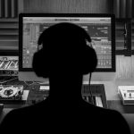 Man produce electronic music in project home studio. Silhouette. Black and white photo.